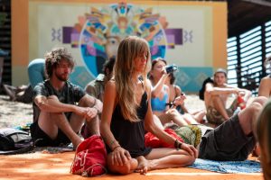 [:es]Group of adults meditating outdoors during summer retreat. Relaxation and mindfulness theme.[:]